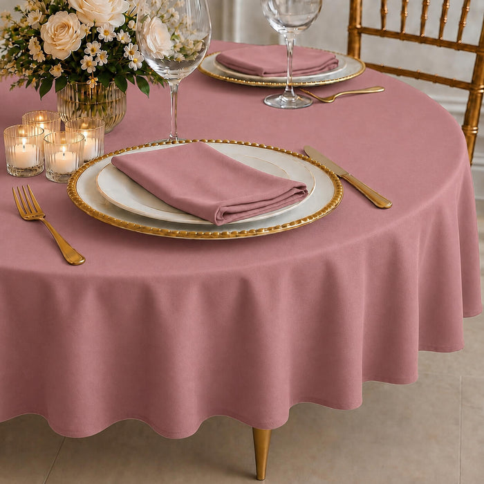 Dusty rose round tablecloth on a dining table with elegant table settings.