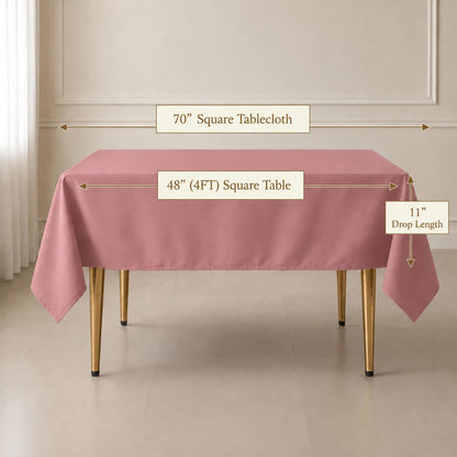A dusty rose square tablecloth draped over a rectangular table in a bright room, with measurement labels showing 70" square tablecloth, 48" by 4FT table, and 11" drop length.