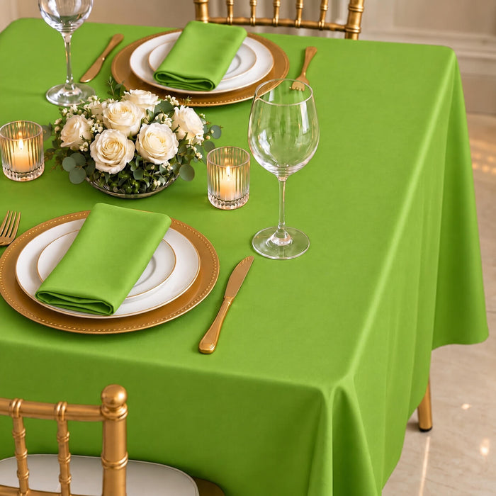 Apple green polyester tablecloth on a dining table set with dishes and flowers.