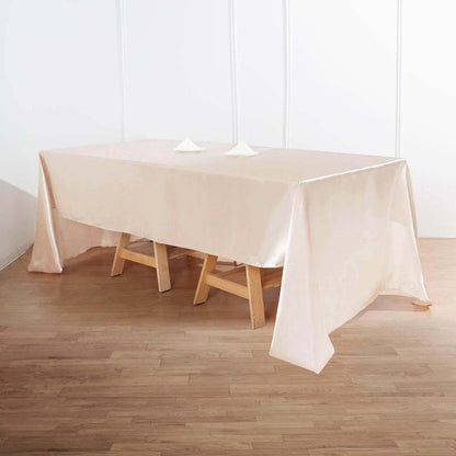 Elegant beige tablecloth draped over a wooden table for events or dining.