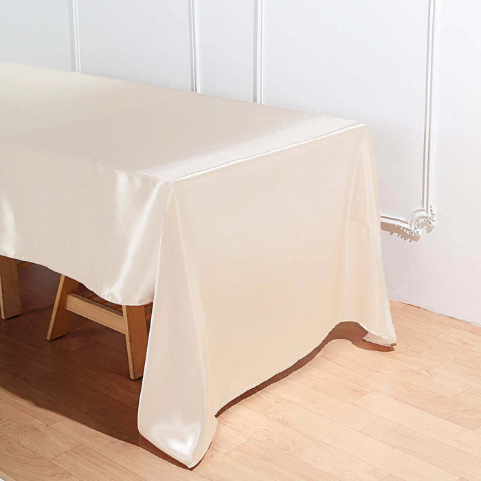 Cream satin tablecloth draped over a wooden table.