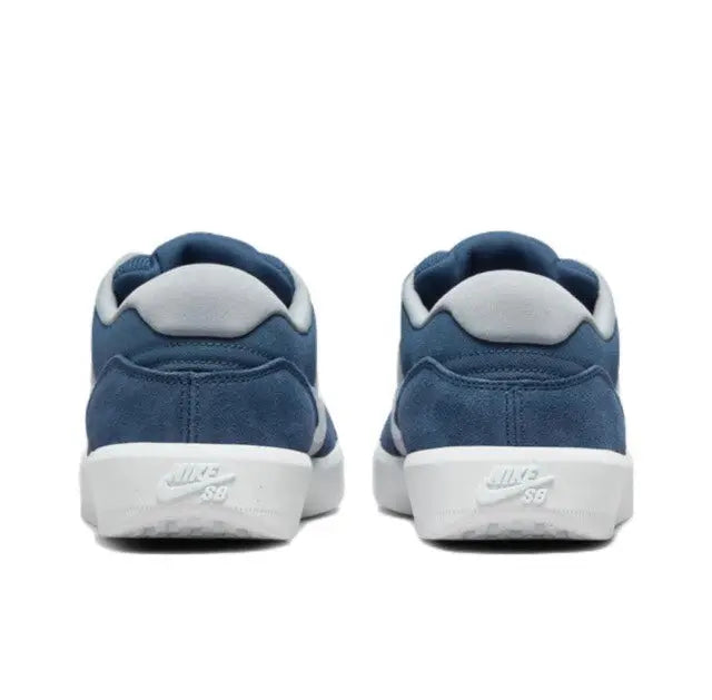 Blue low-top skate sneakers, white midsole and heel tab logo