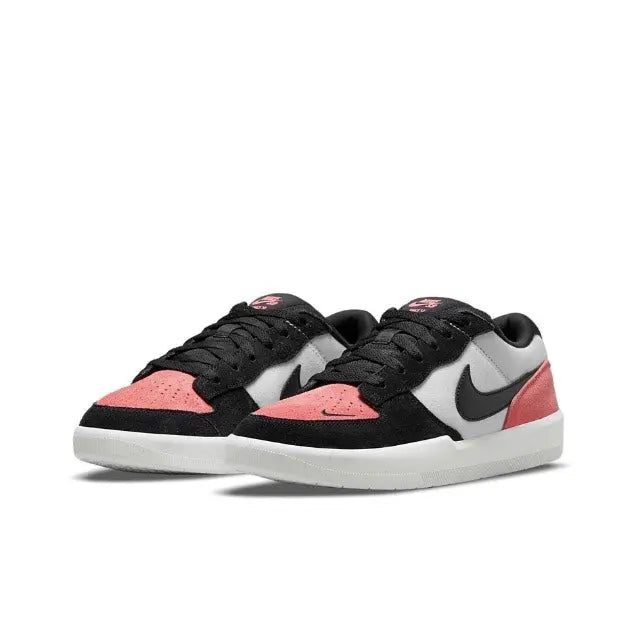 Pair of low-top Nike SB sneakers in black with white panels and pink accents