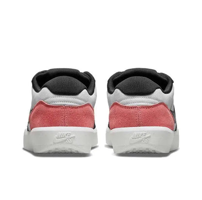 Low-top Nike SB sneakers with pink heel panels, black collar, and white midsole