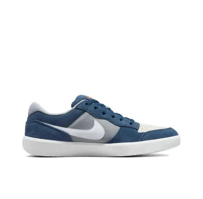 Blue and white low-top skate sneakers, lateral view with white swoosh and gray panel