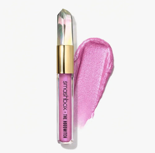 Shimmery pink liquid eyeshadow with crystal-shaped cap and swatch on white background