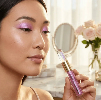 Woman wearing shimmery pink eyeshadow holding Smashbox crystal-shaped eyeshadow tube
