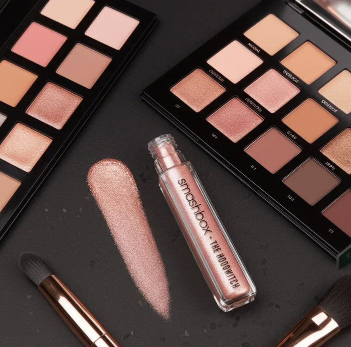 Shimmery pink Smashbox liquid eyeshadow with neutral eyeshadow palettes and makeup brushes
