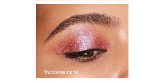 Close-up of eyelid with pink shimmer eyeshadow labeled Rhodonite Stand