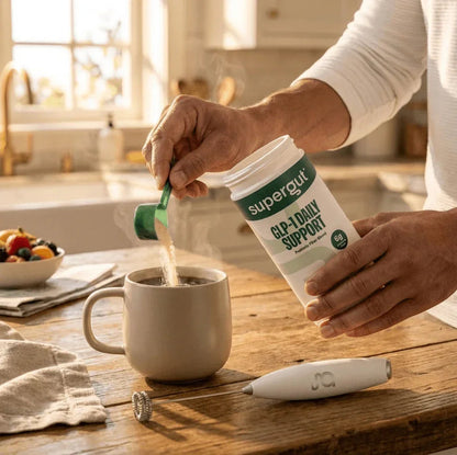 Supergut GLP-1 Daily Support prebiotic fiber powder being added to coffee in a kitchen