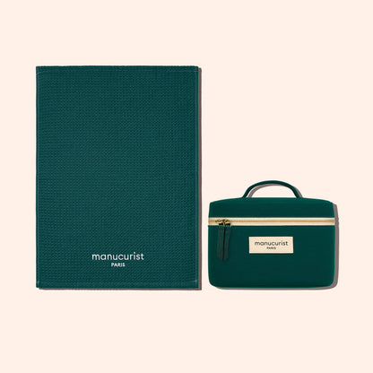 A dark green, textured organic cotton Towel from Manucurist-us and a matching zippered pouch provide stylish surface protection, both labeled with the brand and displayed on a light beige background.