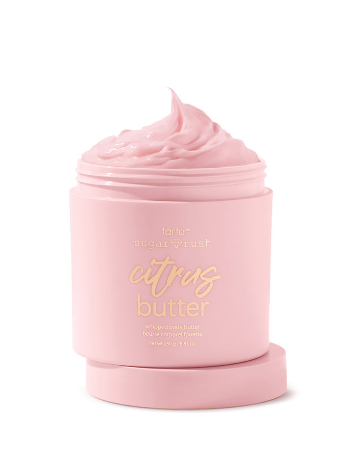 Pink jar of 'citrus butter' body scrub with visible brand name on a white background