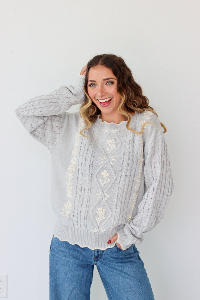 Woman wearing a knit light purple sweater against a white background