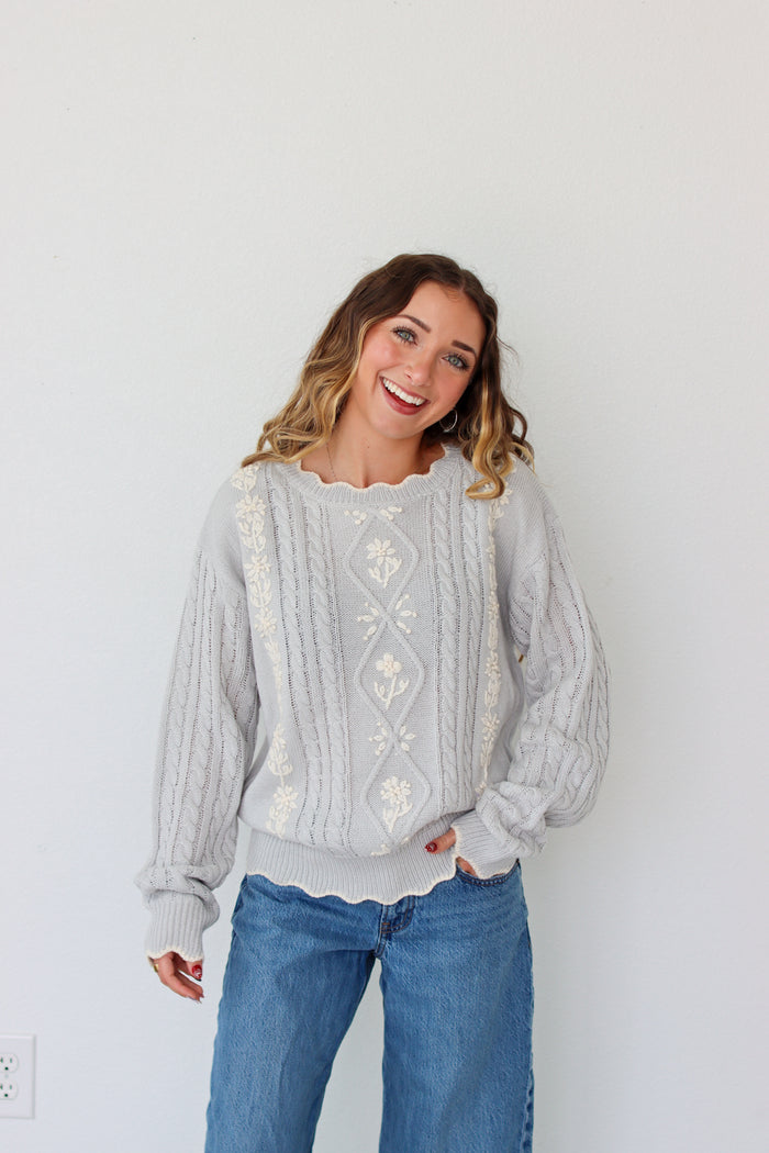 Woman wearing a knit light purple sweater against a white background